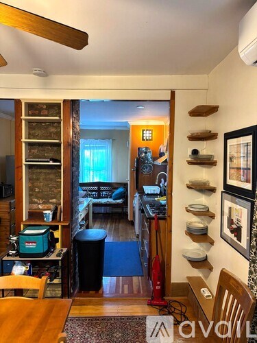 A living room with a brown table and chairs, a television, and a bookshelf.