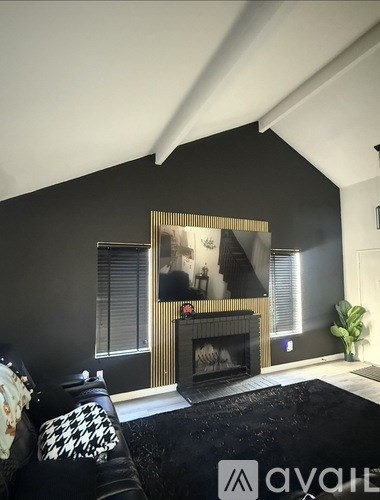 A black and white checkered couch sits in front of a fireplace in a modern living room.