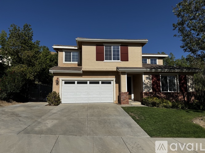 A two-story house with a garage is available for sale.