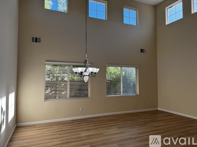 A room with wooden floors and a chandelier hanging from the ceiling.