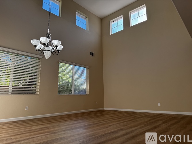 A room with wooden floors and a chandelier hanging from the ceiling.