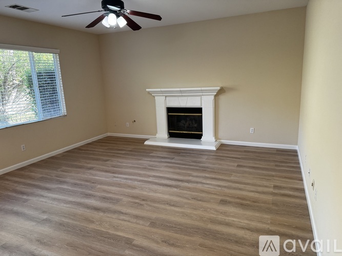 A room with a fireplace and a ceiling fan.