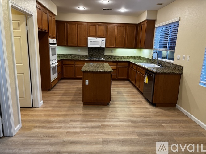 A kitchen with wooden cabinets and a granite countertop.