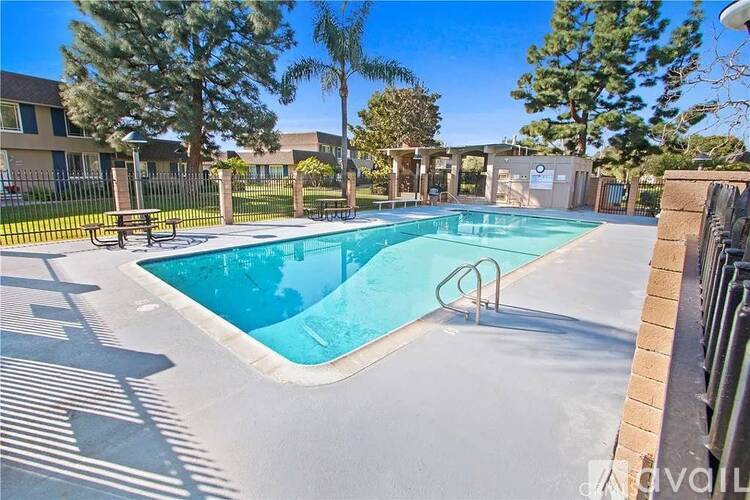 A swimming pool surrounded by a fence and trees.