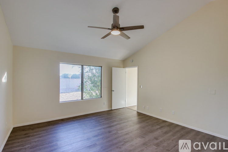 A spacious room with a ceiling fan and sliding glass doors.