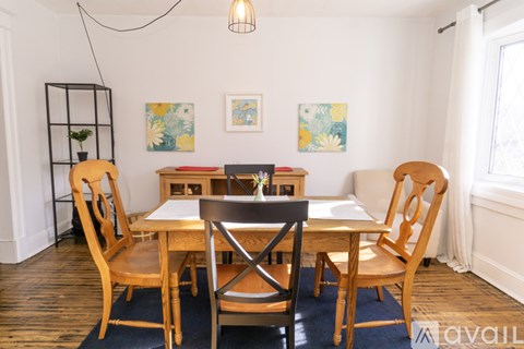 A dining room with a table and chairs.