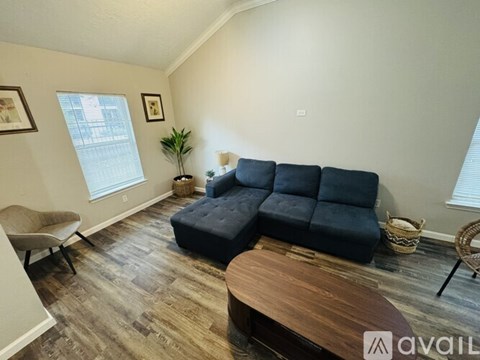 A living room with a blue couch and a wooden coffee table.