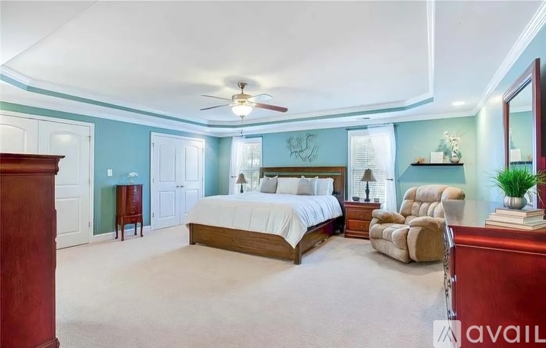 A bedroom with a large bed and a ceiling fan.
