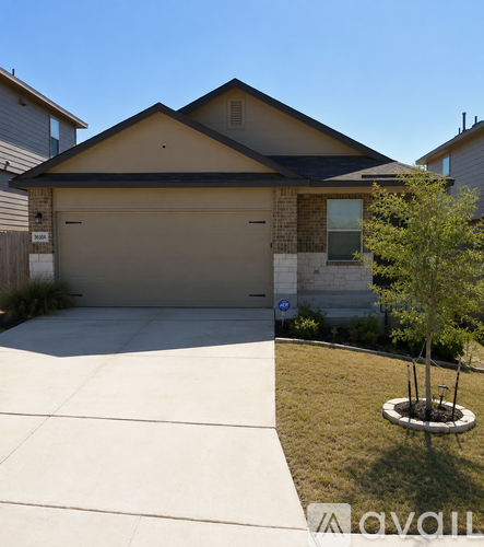 A house with a garage and a tree in front.