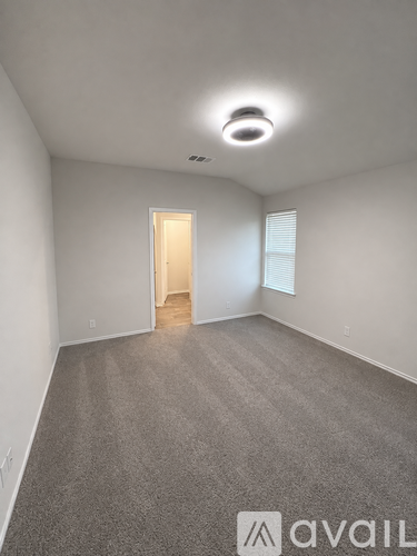 A room with a carpeted floor and a door in the middle.
