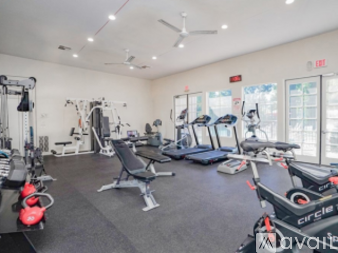 A gym with a variety of equipment including treadmills, weights, and exercise machines.