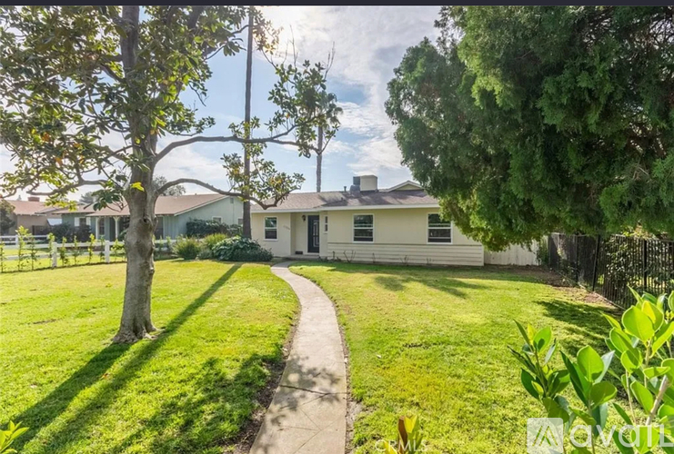 A house with a white fence and a green lawn.
