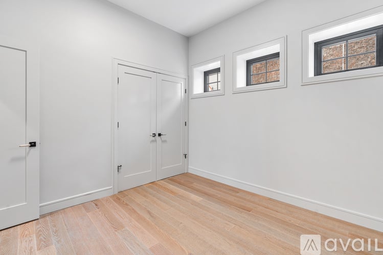 A room with two doors and two windows.