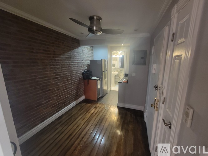 A room with a ceiling fan and wooden flooring.