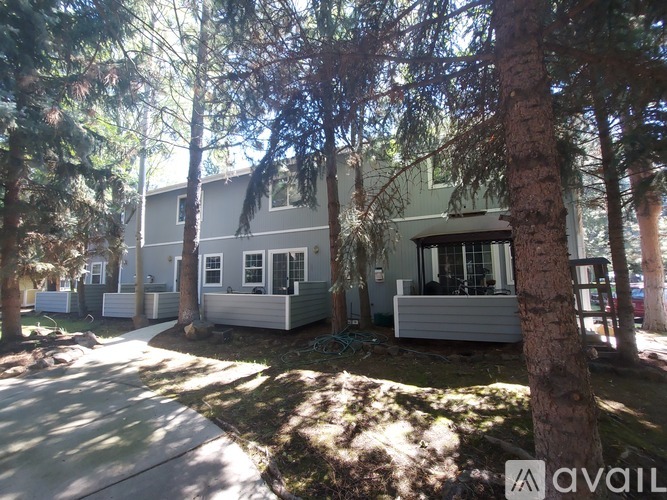 A row of houses with trees in front.