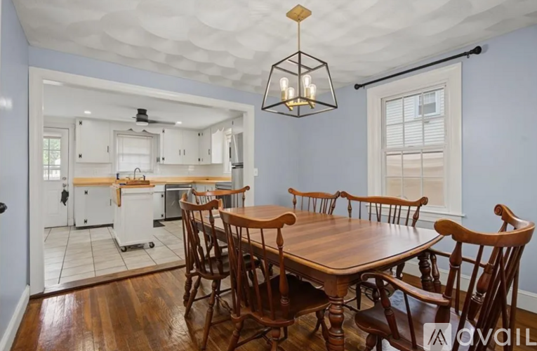 A dining room with a wooden table and chairs.