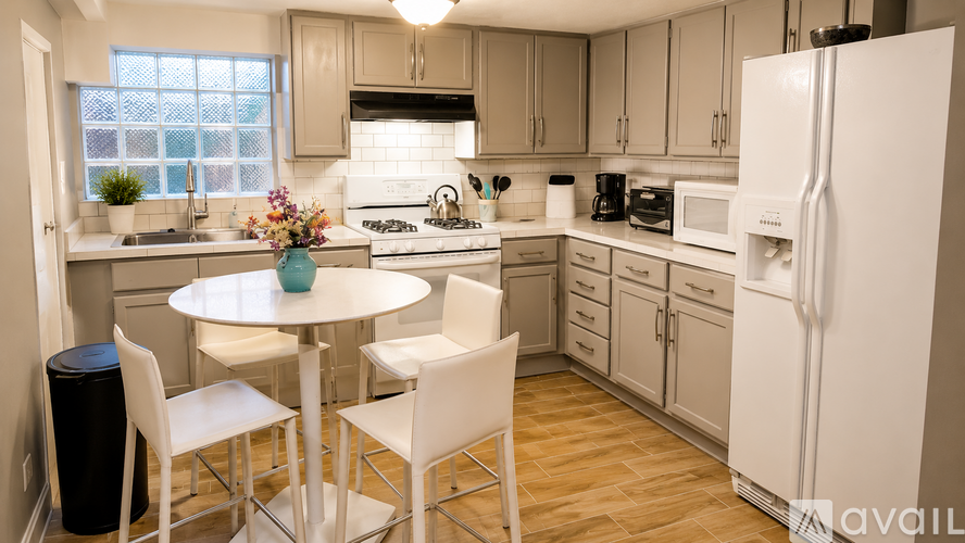 A kitchen with a table and chairs.
