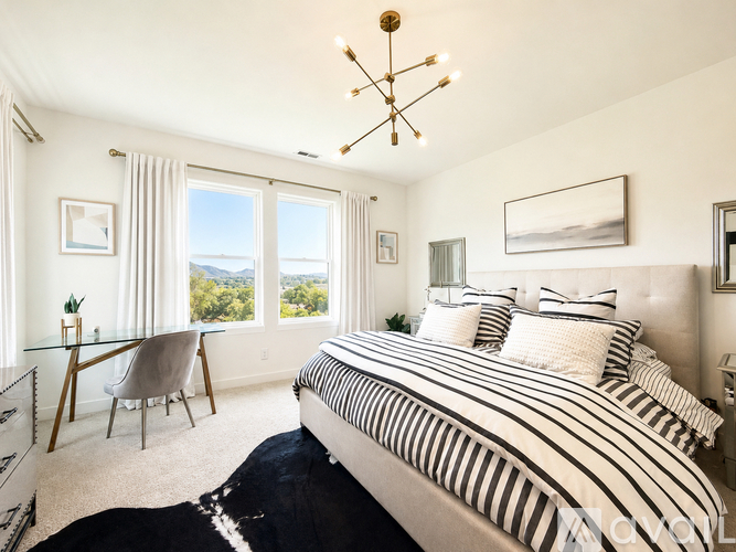A bedroom with a large bed and a view of the mountains.