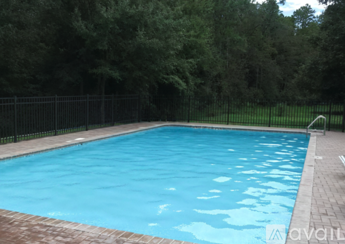 A rectangular pool with a black fence around it.