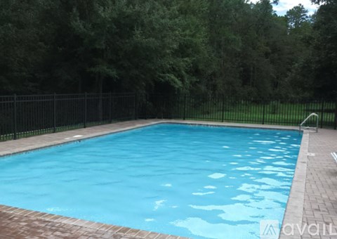 A rectangular pool with a black fence around it.
