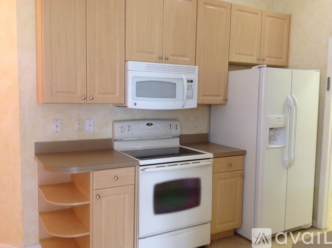 A kitchen with wooden cabinets and white appliances.