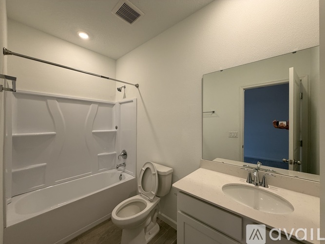A bathroom with a toilet, sink, and bathtub.