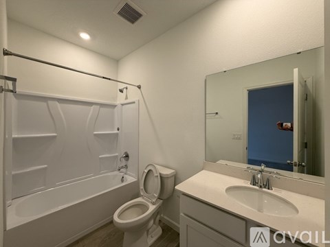 A bathroom with a toilet, sink, and bathtub.