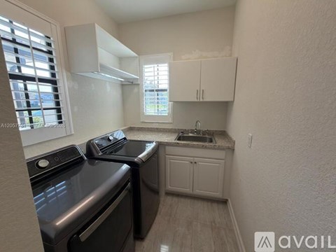 A small kitchen with a black oven and white cabinets.