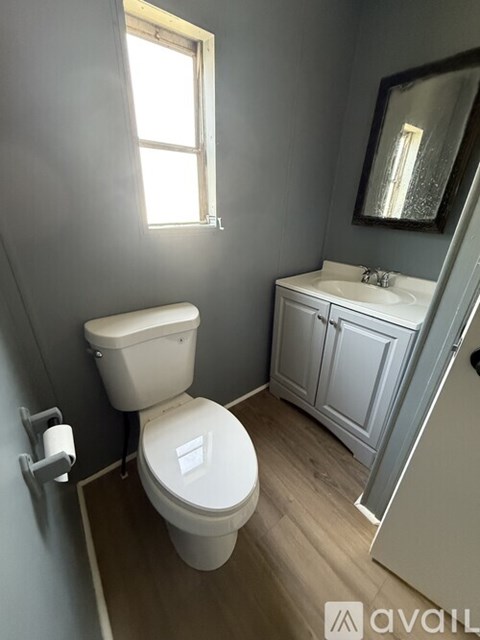 A bathroom with a toilet, sink, and medicine cabinet.