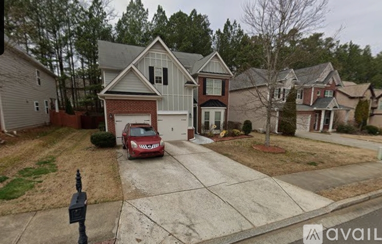 A house with a red car parked in front.