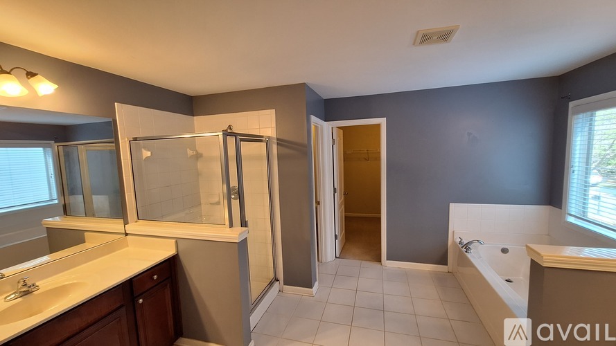 A bathroom with a sink, mirror, bathtub, and shower.