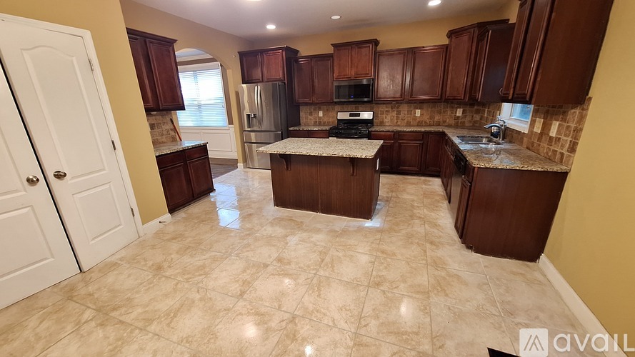 A kitchen with brown cabinets and a tiled floor.