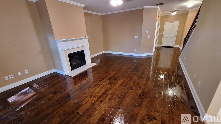 A living room with a fireplace and wood flooring.