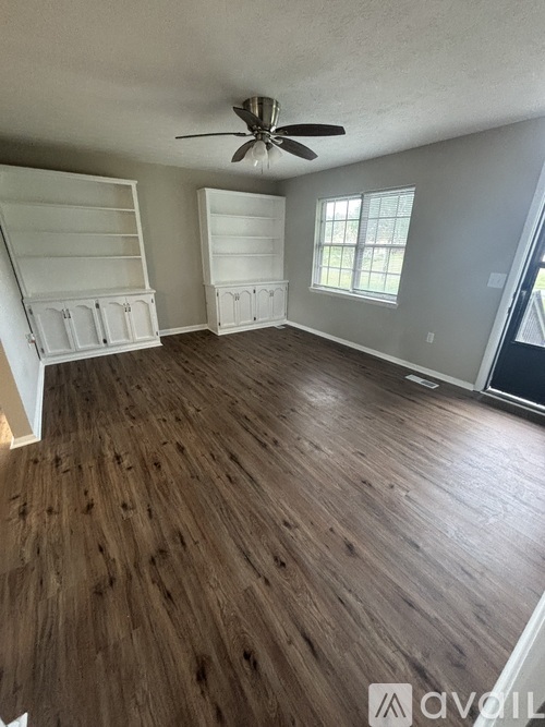 A room with wooden floors and a ceiling fan.