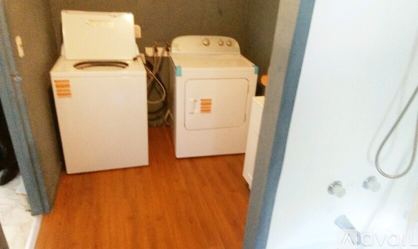 A small bathroom with a toilet and a washing machine.