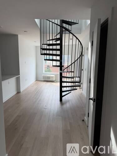 A spiral staircase in a room with wooden flooring.