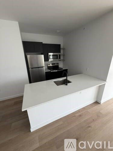 A kitchen with a white countertop and stainless steel appliances.