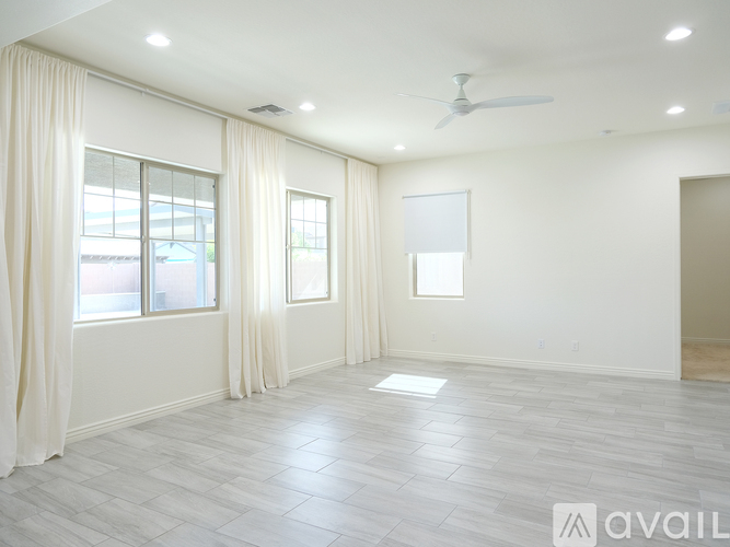 A spacious room with a fan and large windows.