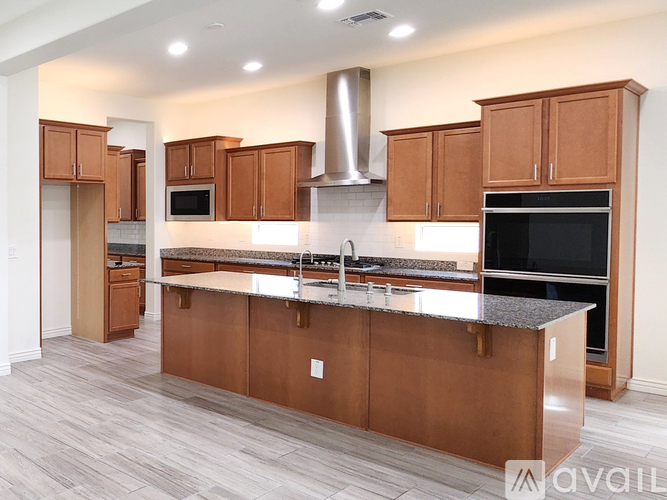 A kitchen with wooden cabinets and a stainless steel island.