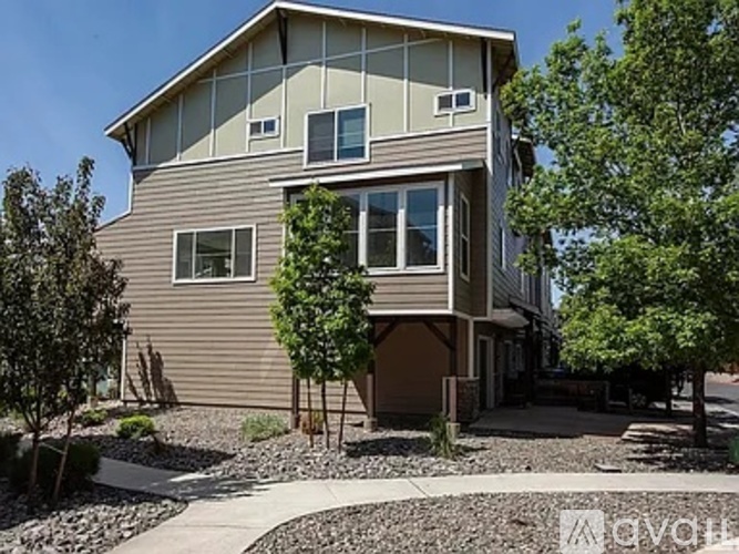 A modern house with a brown exterior and a large front yard.