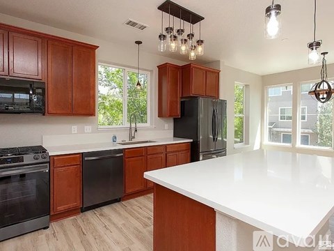 A kitchen with wooden cabinets and black appliances.