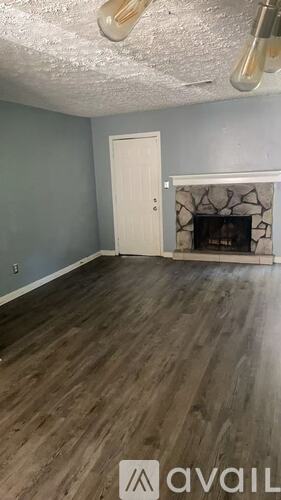 A room with a fireplace and wooden flooring.