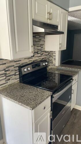 A kitchen with a black stove top oven and a white dishwasher.