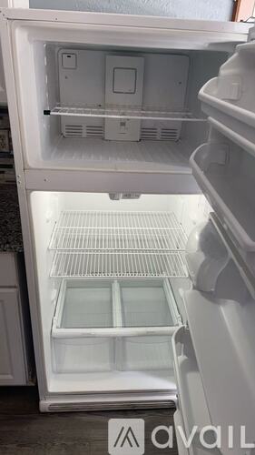 A white refrigerator with the door open and shelves visible.