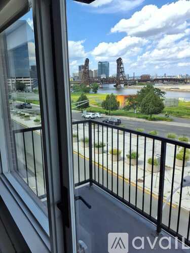 A view from a balcony looking out at a cityscape with a river and bridge.
