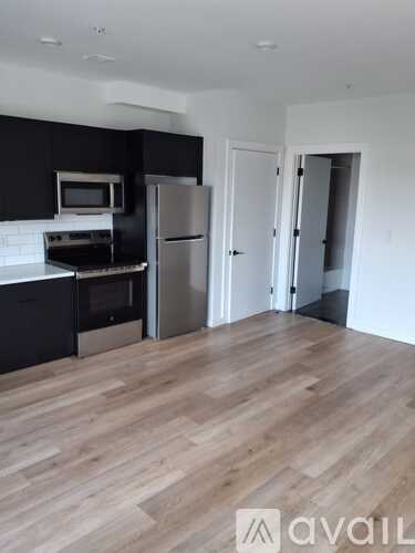 A kitchen with a refrigerator, microwave, and oven.