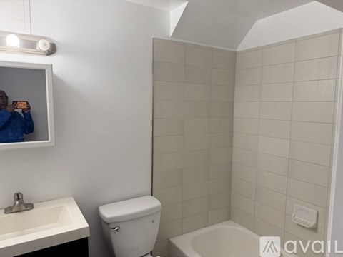 A bathroom with a toilet, sink, and bathtub.