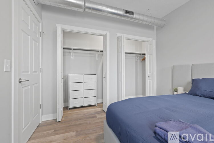 A bedroom with a bed, dresser, and closet.