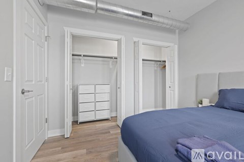A bedroom with a bed, dresser, and closet.