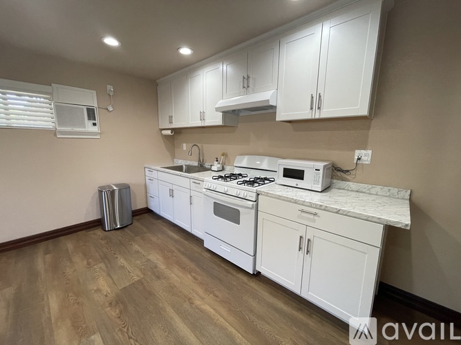 A kitchen with white appliances and cabinets.